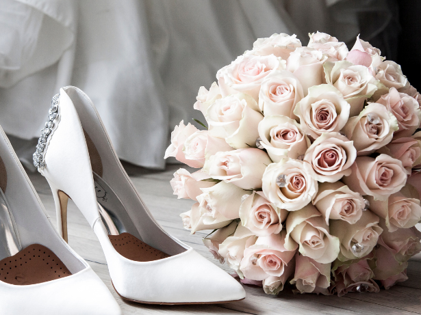 Weiße Hochzeitsschuhe neben einem Strauß aus rosa Rosen. Weiße Hochzeitsschuhe neben einem Strauß aus rosa Rosen. Romantische Hochzeit