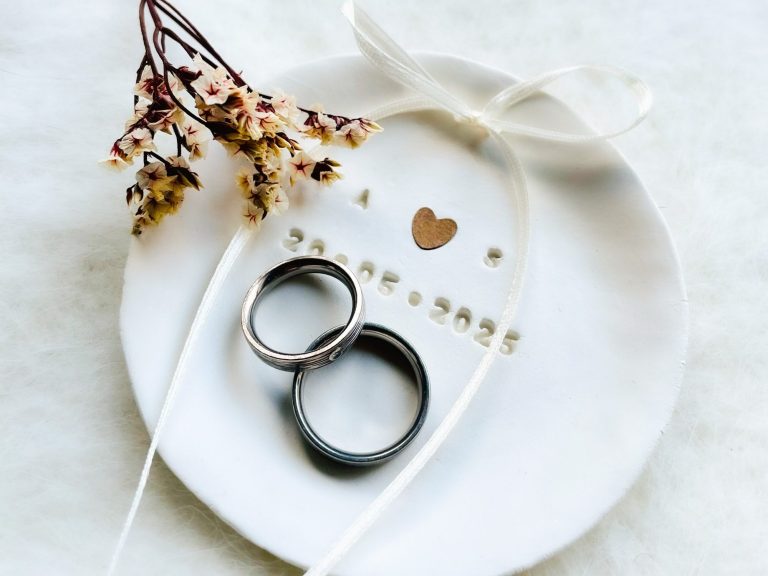 Ringteller romantsich Hochzeit für Eheringe handgetöpfert im Atelier Zwei Ringe auf einem Teller mit Herzdekor und Trockenblumen.