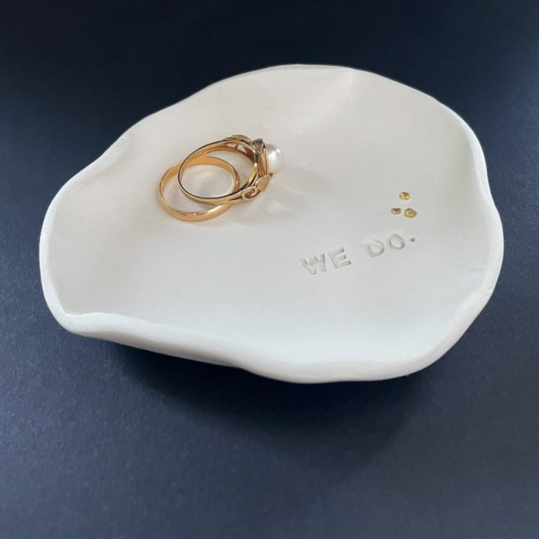 Feine Keramik Ringschale mit Champagner-Details – liebevoll gefertigt in Handarbeit Vase mit Blumen auf einem Tisch im Freien, umgeben von Lichterketten.