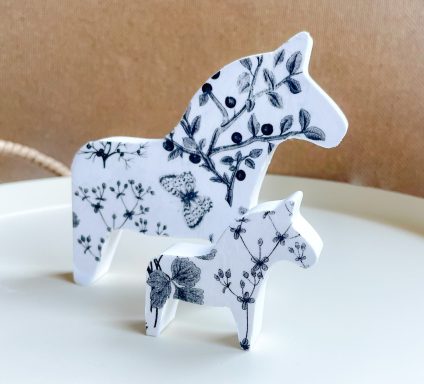 Zwei dekorative Figuren eines Pferdes und eines Fohlens mit floralen Mustern.