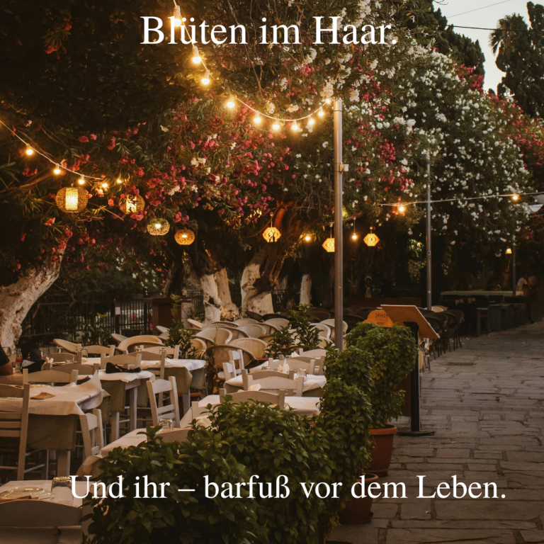 Gemütlicher Außenbereich eines Restaurants mit lichterfüllten Bäumen und Tischen.